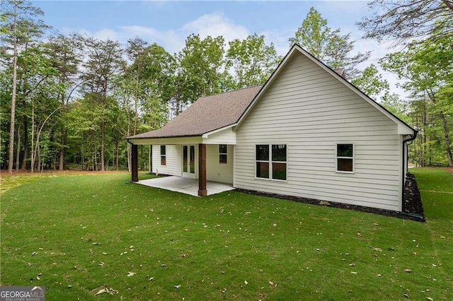 rear view of property featuring a lawn and a patio area