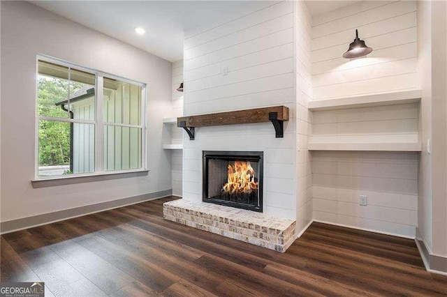 unfurnished living room with wood finished floors, baseboards, a fireplace, and recessed lighting