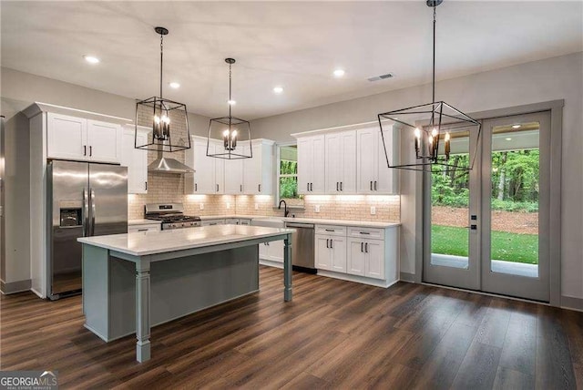 kitchen with stainless steel appliances, a chandelier, light countertops, dark wood-type flooring, and recessed lighting