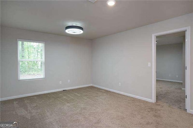 carpeted spare room with baseboards