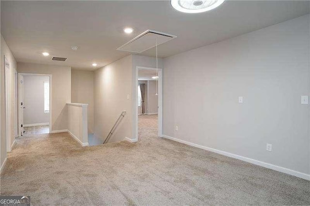 unfurnished room with attic access, baseboards, recessed lighting, and carpet