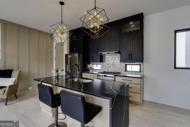 1968 8th St, Chamblee, GA 30341 - kitchen with appliances with stainless steel finishes, light wood-type flooring, a chandelier, a kitchen breakfast bar, and backsplash