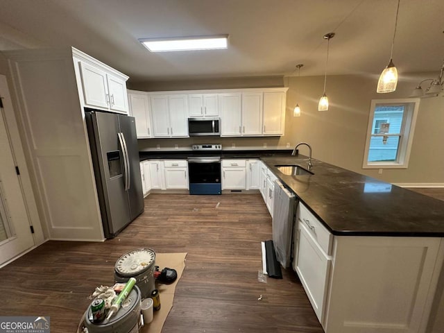 113 Sidetrack Cir, Comer, GA 30629 - kitchen featuring stainless steel appliances, a sink, a peninsula, dark countertops, and dark wood-style flooring