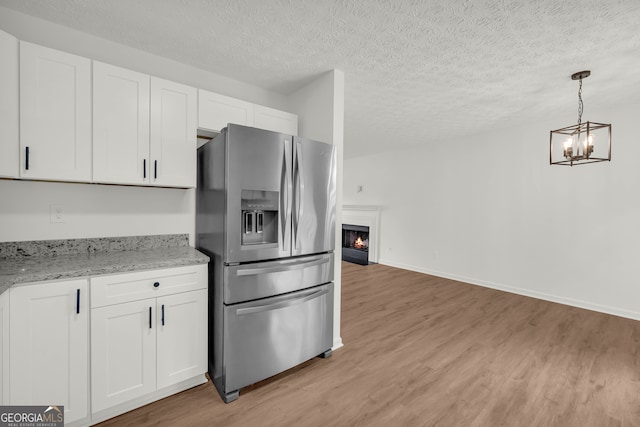 1645 Cobbs Creek Ln, Decatur, GA 30032 - kitchen with stainless steel refrigerator with ice dispenser, light wood-type flooring, white cabinets, and a textured ceiling