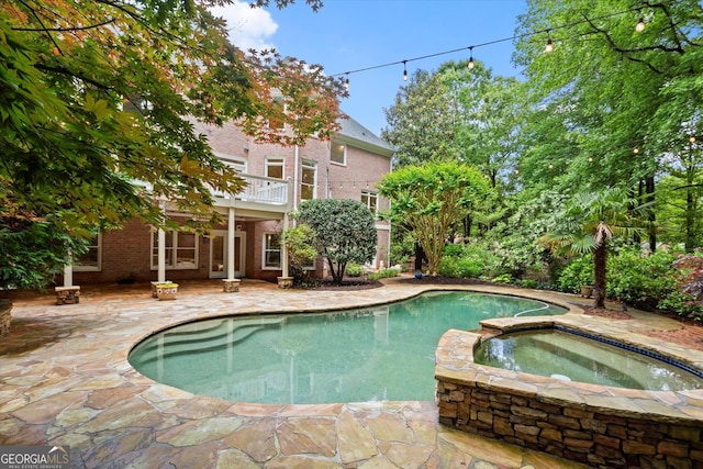 view of pool featuring a patio and a pool with connected hot tub