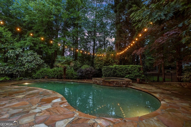 view of pool featuring a patio area, a pool with connected hot tub, and fence