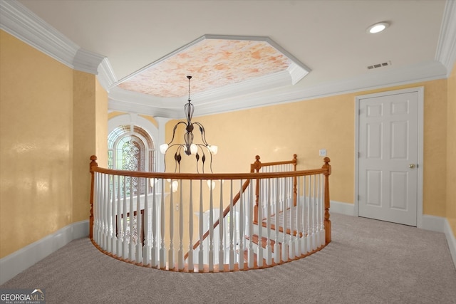 hall with ornamental molding, an upstairs landing, a chandelier, carpet flooring, and baseboards