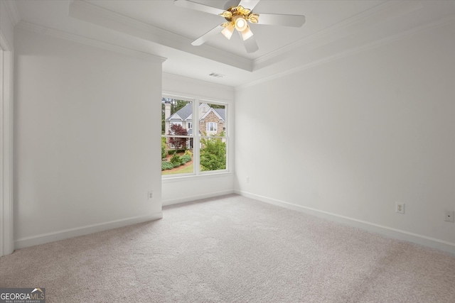 unfurnished room with a raised ceiling, crown molding, carpet, baseboards, and ceiling fan