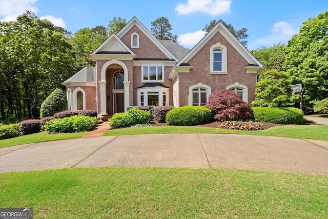 colonial house with brick siding and a front yard