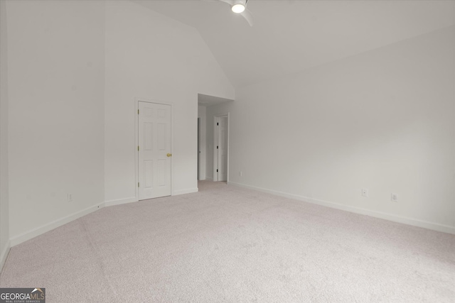 unfurnished room with a ceiling fan, light colored carpet, baseboards, and high vaulted ceiling