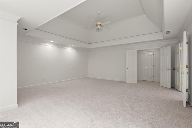 unfurnished bedroom with carpet flooring, ornamental molding, a raised ceiling, baseboards, and a ceiling fan