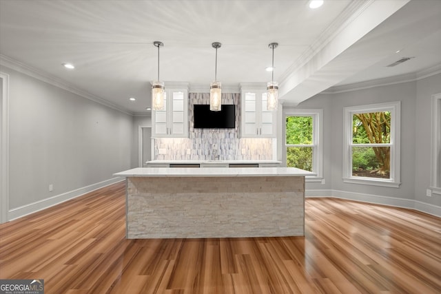 kitchen with light wood-style flooring, white cabinetry, a kitchen island, light countertops, and recessed lighting