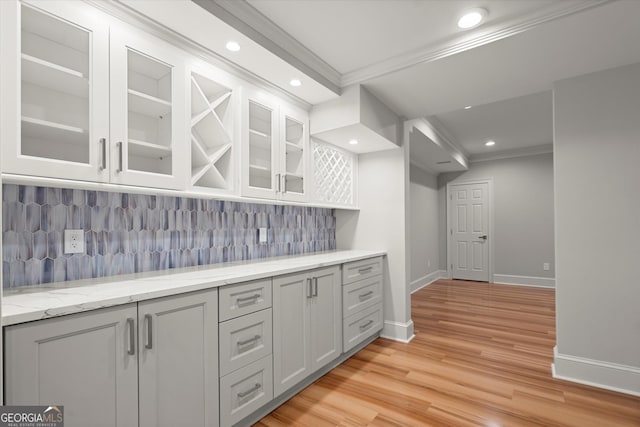 bar area featuring ornamental molding, baseboards, tasteful backsplash, light wood-style floors, and recessed lighting