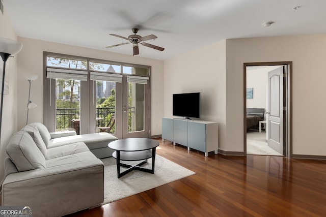living room featuring a ceiling fan, wood finished floors, and baseboards