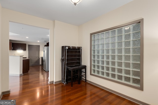 empty room featuring dark wood-style flooring, baseboards, and recessed lighting