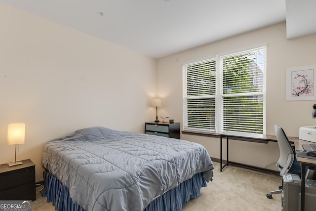 bedroom featuring light colored carpet and a desk