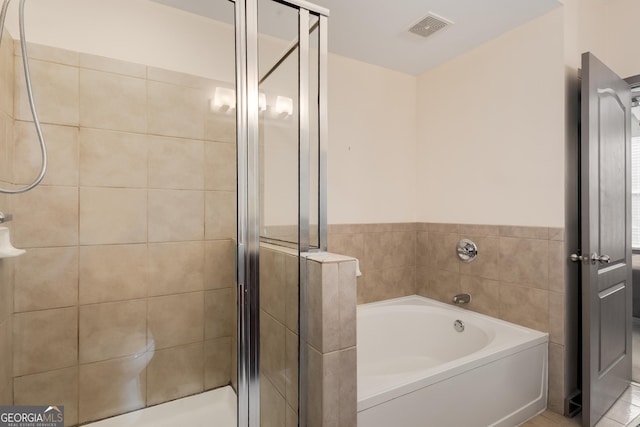 bathroom featuring a stall shower and a bath