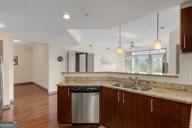 kitchen featuring stainless steel dishwasher, a sink, dark wood finished floors, ceiling fan, and light stone counters