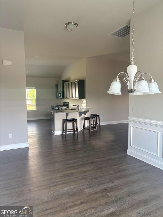 dining room featuring vaulted ceiling, dark wood-type flooring, and baseboards