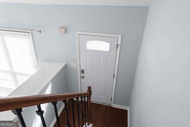 foyer entrance with dark wood-style floors and baseboards