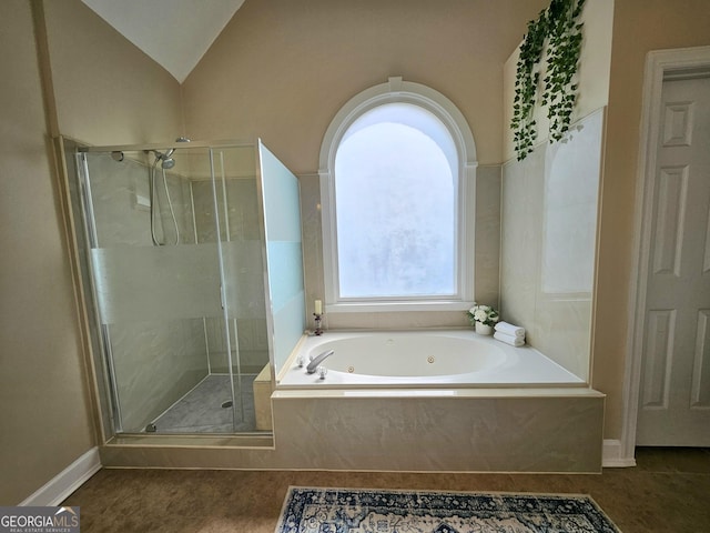 full bath featuring a stall shower, a jetted tub, and lofted ceiling