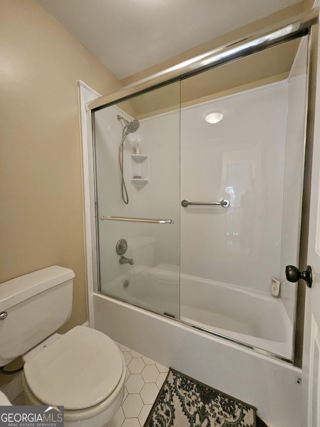 bathroom with toilet, bath / shower combo with glass door, and tile patterned floors