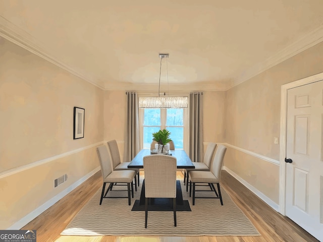 dining space featuring ornamental molding, wood finished floors, and baseboards