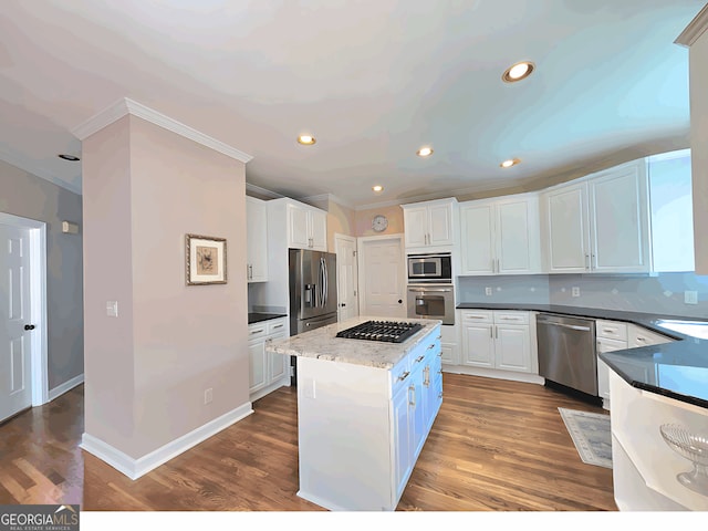 kitchen with stainless steel appliances, crown molding, white cabinets, a kitchen island, and tasteful backsplash