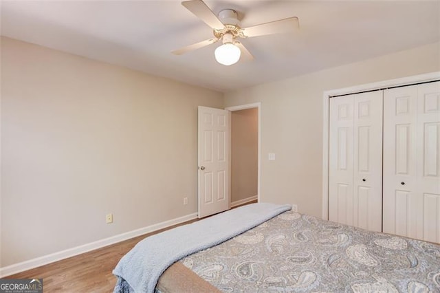 bedroom featuring baseboards, wood finished floors, a closet, and a ceiling fan