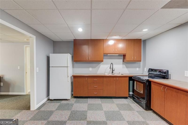 kitchen with freestanding refrigerator, black / electric stove, a sink, light countertops, and a paneled ceiling