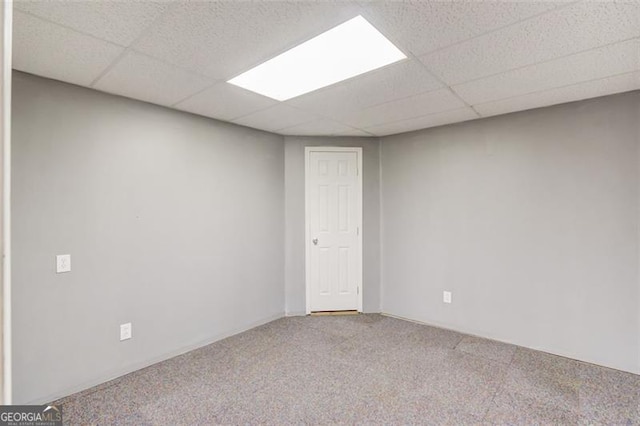 spare room featuring a drop ceiling and carpet flooring