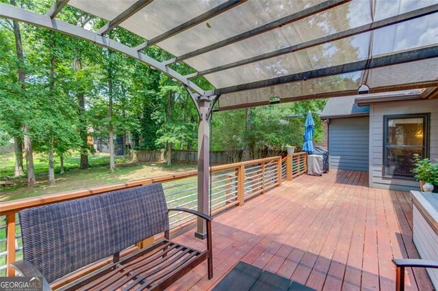 view of patio featuring a wooden deck, fence, and a pergola