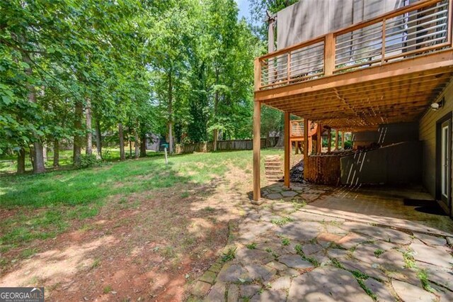 view of yard featuring a deck, a carport, and a patio area