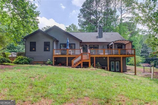 back of property with a deck, french doors, a lawn, and a chimney