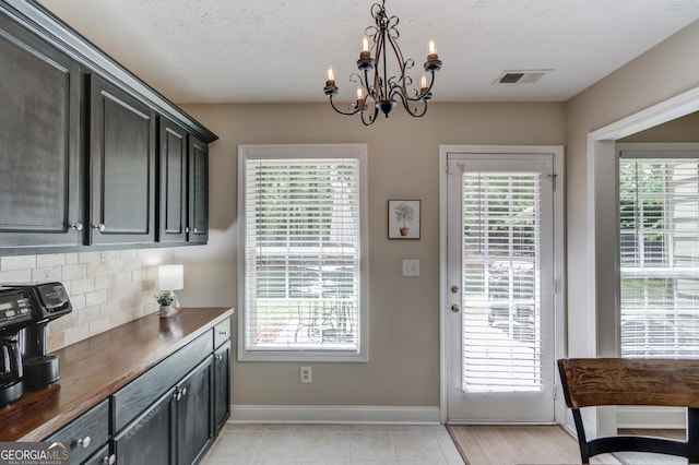 doorway with a chandelier, healthy amount of natural light, and baseboards