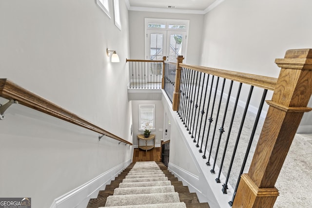 stairway featuring baseboards, crown molding, and wood finished floors