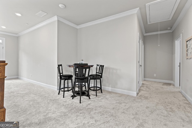 carpeted dining area with attic access, crown molding, baseboards, and recessed lighting