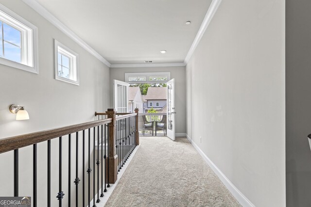corridor featuring ornamental molding, light carpet, and baseboards