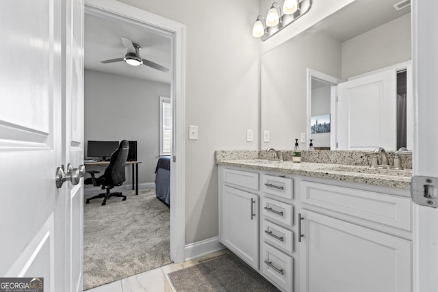 full bathroom featuring double vanity, ceiling fan, and baseboards