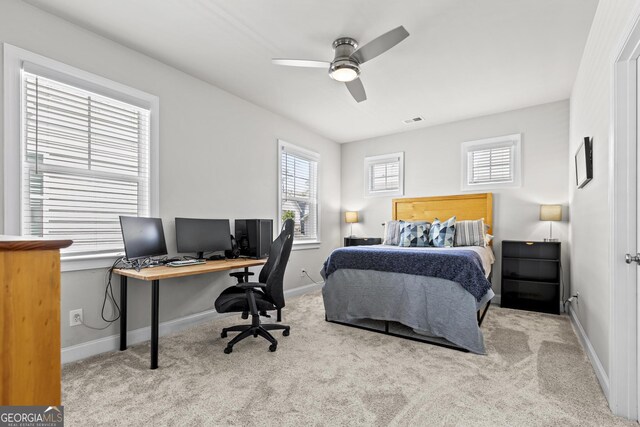 carpeted bedroom with a desk, baseboards, and ceiling fan