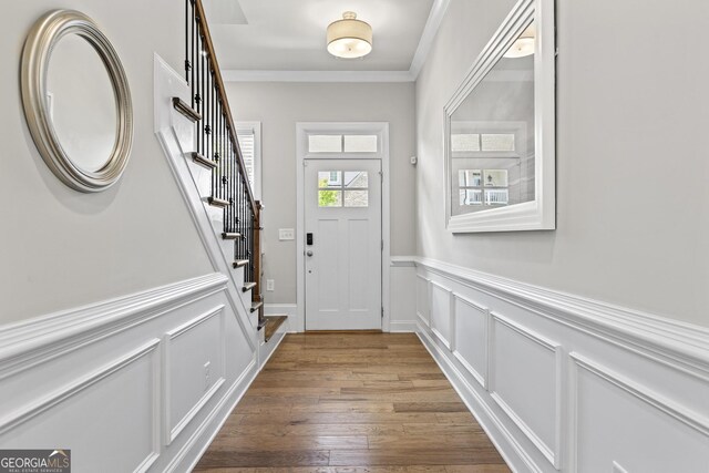 553 Onyx Lndg, Marietta, GA 30064 - entryway featuring stairs, a wainscoted wall, crown molding, wood finished floors, and a decorative wall