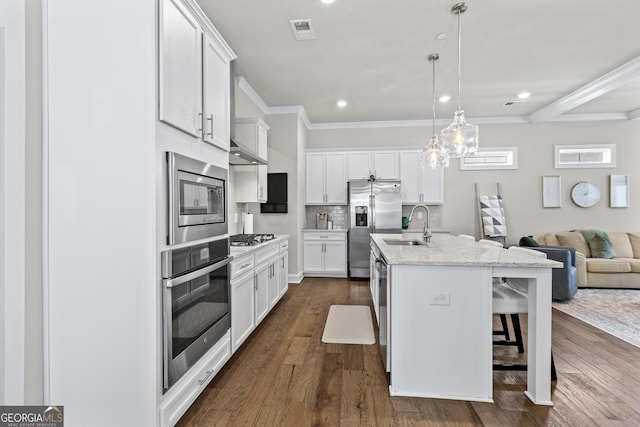kitchen featuring stainless steel appliances, a sink, dark wood-type flooring, open floor plan, and white cabinets