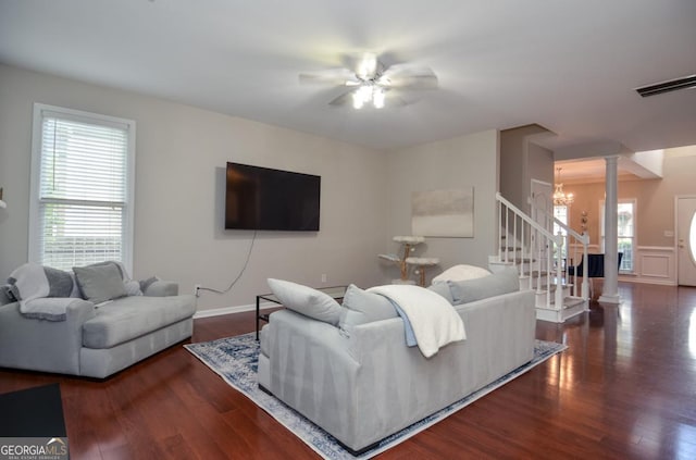 living area with stairway, wood finished floors, a chandelier, and healthy amount of natural light