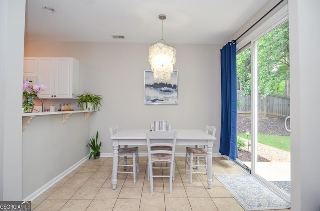 dining space featuring a chandelier, light tile patterned floors, and baseboards
