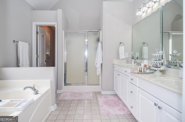 full bathroom with a shower stall, double vanity, a garden tub, and baseboards
