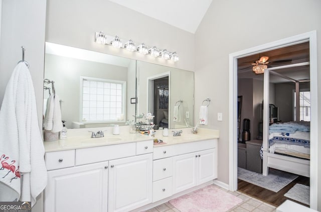 full bath with ensuite bath, lofted ceiling, and double vanity