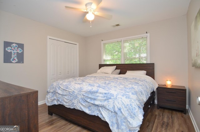 bedroom with a closet, wood finished floors, and baseboards
