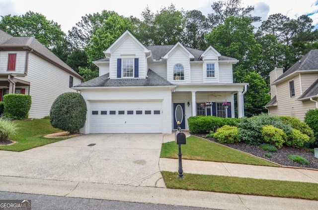 traditional home with driveway, a garage, a shingled roof, and a front yard