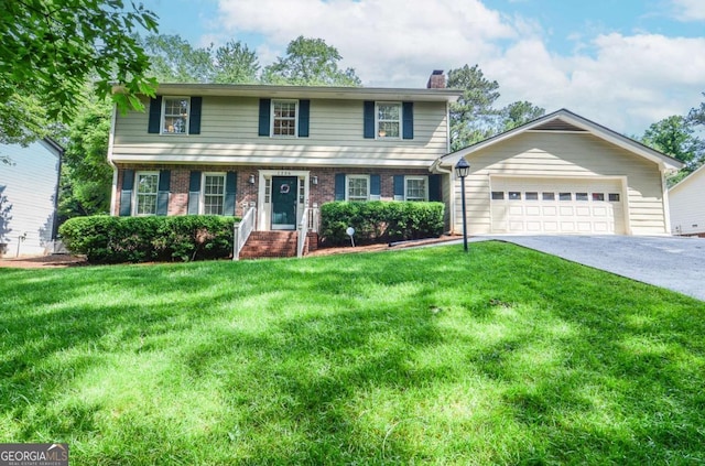 view of front of property with a chimney, driveway, a front lawn, an attached garage, and brick siding