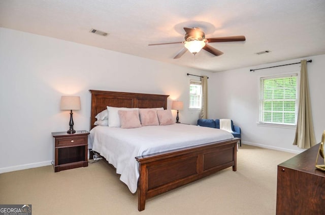 bedroom with light carpet, multiple windows, baseboards, and ceiling fan